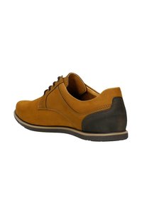 Hnědé semišové boty s kulatou špičkou, hnědými tkaničkami a tmavým gumovým krytem na patě; mají hladký povrch a jednoduché švy.