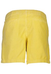 Gula kordshorts med elastisk midja, två bakfickor och ett strukturerat ribbat mönster. Hemfälserna är lätt upprullade.