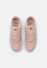 Ljust rosa lädersneakers med texturerad yta, perforerad tåbox och vit gummisul. Logotyper på tungan och innersulorna i svart.