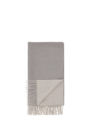 Couverture grise avec un dessous gris clair, présentant des bords frangés et un petit accent doré. Texture lisse et forme rectangulaire.