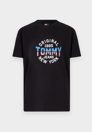 Črna bombažna majica s velikim grafičnim tiskom z napisom "TOMMY" v modrih in rdečih črtastih črkah, obdanimi z belim in rdečim besedilom.