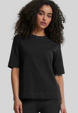 Black short-sleeve t-shirt made from soft cotton. Features a round neckline, relaxed fit, and minimal stitching detail.