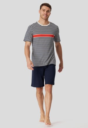 Striped short-sleeve shirt in navy and white with a red horizontal accent; paired with navy shorts; cotton material, relaxed fit, casual style.