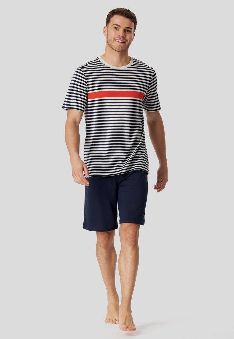 Striped short-sleeve shirt in navy and white with a red horizontal accent; paired with navy shorts; cotton material, relaxed fit, casual style.