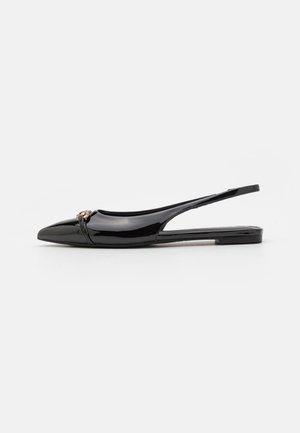 Czarny lakierowany płaski but na pasku z tyłu z ostrym czubkiem i małym metalowym ozdobnym detalem z przodu.