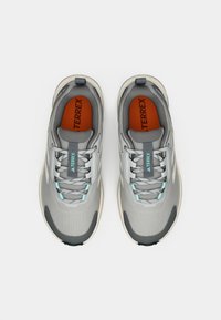 Γκρι αθλητικά παπούτσια με ανώτερο μέρος από δίχτυ, γαλάζιες λεπτομέρειες και πορτοκαλί πάτους. Διαθέτουν καουτσούκ σόλα και ενισχυμένη περιοχή στα δάχτυλα.