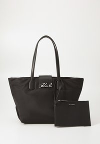 Black nylon tote bag with two handles, featuring silver logo accents and a detachable zippered pouch. Smooth texture with structured shape.