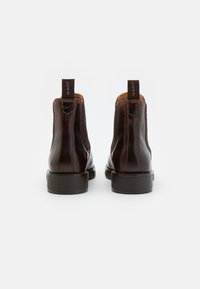 Braune Leder Chelsea Boots mit elastischen seitlichen Einsätzen, verstärkten Nähten und strukturierten Ziehfäden auf der Rückseite. Flache Gummisohlen.