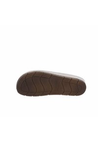 Suola di una scarpa con una superficie in gomma marrone texture, con scanalature ben definite e un tallone bianco, etichettata "Flexima Soft Walking."