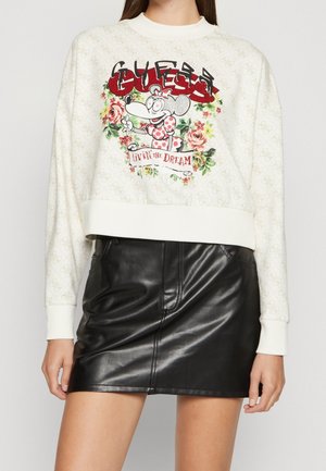 Hvid sweatshirt med tegneserie-mus, rød "GUESS" tekst, blomsterbaggrund, "Livin' the Dream" banner, kombineret med sort læder mininederdel.