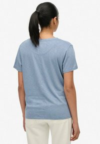 Kortærmet blå t-shirt i blød bomuldsblanding, har rund hals og afslappet pasform, med minimale sømdetaljer på ryggen.