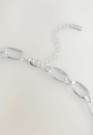 Silberne Kettenarmband mit großen ovalen Gliedern und einem Karabinerhaken, ausgestattet mit einer verstellbaren Verlängerungskette und einem rechteckigen Anhänger.