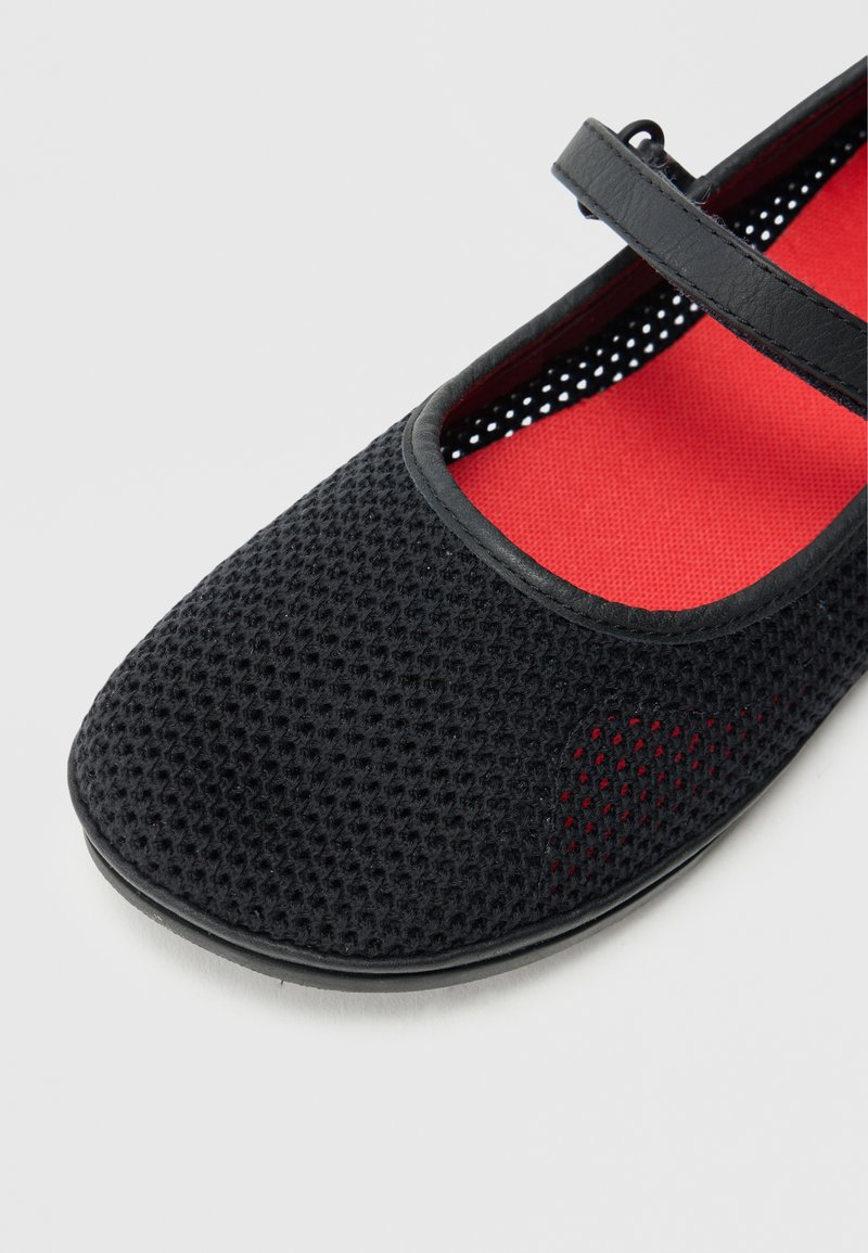 Black mesh Mary Jane shoe with a red insole, featuring a thin strap and a round toe, designed for breathability and comfort.