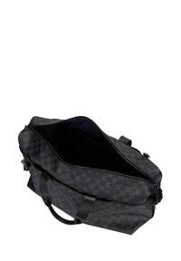 Czarna torba sportowa w kratę z zamkiem błyskawicznym na górze, wykonana z teksturowanego syntetycznego materiału, z dwoma czarnymi uchwytami. Wnętrze jest ciemne, z przegródkami.