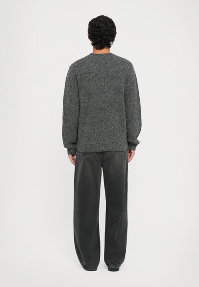Gray textured knit sweater with a round neckline, long sleeves, and a relaxed fit, paired with loose-fitting dark gray pants.