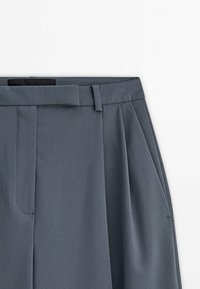 Grijze op maat gemaakte broeken met een gladde textuur, geplooid voorpand en een tailleband. Voorzien van riemlussen en zijzakken.