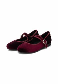 Zapatos planos Mary Jane de terciopelo burdeos con punta redondeada, correa en el empeine y un pequeño detalle de hebilla lateral. Textura suave y tacón bajo.