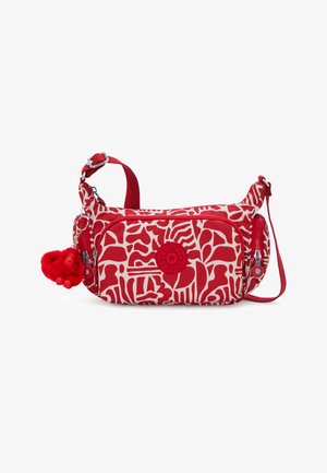 Rode tas met witte abstracte patronen, voorzien van een hoofdvak met ritssluiting, verstelbare band en een rood sleutelhanger in de vorm van een aap.