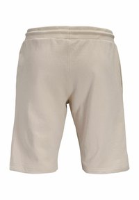 Shorts décontractés beiges avec taille élastique et poches latérales, vus de dos.