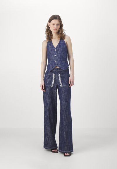 Denimvest og utsvingte bukser i mørkeblått med teksturert overflate. Vest har v-hals og tre knapper; bukser har slitte frontlommer.