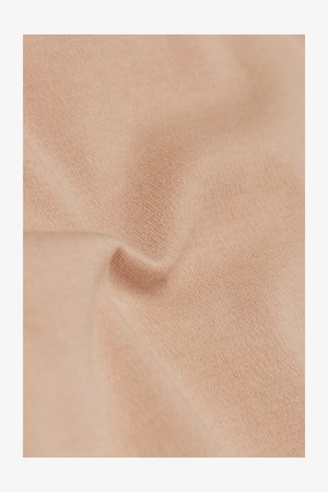 Tela suave de tono beige claro con textura de punto visible y pliegues sutiles que muestran arrugas suaves y caídas delicadas.