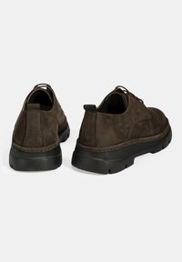 Chaussures en daim marron avec un bout rond, semelle en caoutchouc noire contrastante, lacets et une languette de talon en boucle pour un enfilage facile.