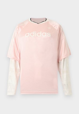 Ροζ μακρυμάνικη μπλούζα Adidas με λευκά μανίκια από δίχτυ με σχέδια και λογότυπο Adidas στο στήθος σε γκρι φόντο.