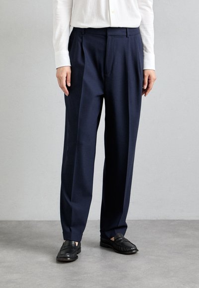 Pantalons taillés bleu marine avec une taille haute, un devant plissé et des jambes larges. Présente une texture douce semblable à de la laine et des passants de ceinture intégrés.