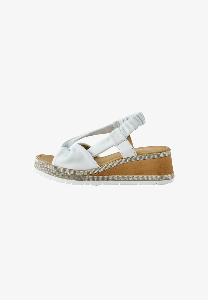 Sandale compensée en cuir blanc avec bride arrière froncée, semelle intérieure rembourrée couleur tan et bordure ornée de strass sur la semelle et le talon compensé blancs.