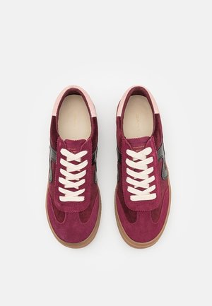 Par de zapatillas de ante burdeos y rosa con cordones blancos, detalles laterales negros y suelas de goma marrón vistas desde arriba.