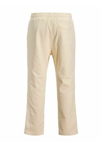 Cremefarvede sweatpants med elastisk talje, lige ben-design og en enkelt baglomme. Blødt, tekstureret stof.