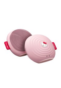 En rosa, cirkulär enhet med en texterad yta med upphöjda prickar och vågor. En liten Hello Kitty-logotyp pryder toppen. Tillverkad av silikonmaterial.