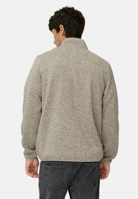 Fleecejacke in Hellbraun, mit hohem Kragen und strukturierter Oberfläche. Lässige Passform mit langen Ärmeln und gerippten Bündchen.