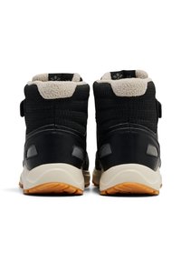 Czarne sneakersy w średniej wysokości wykonane z teksturowanej tkaniny, z kremowym futerkiem od środka i gumową podeszwą. Posiadają rzep oraz wzmocnione detale pięty.