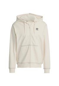 Sudadera cremoso con cremallera fabricada en tela suave, con un bolsillo tipo canguro, capucha ajustable con cordones y el logo negro de Adidas en el pecho.