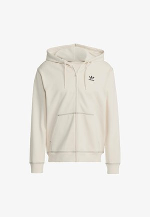 Cream-colored zip-up hoodie made of soft fabric, featuring a kangaroo pocket, adjustable drawstring hood, and black Adidas logo on the chest.