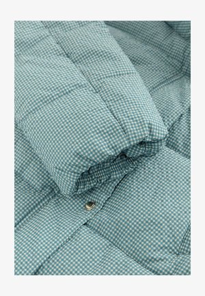 Vaaleansininen tilkkutakki ruudullisella kuvioinnilla, jossa on pehmeä pinta, pönkän muotoilu ja näkyvä metallinen nepparikiinnike.