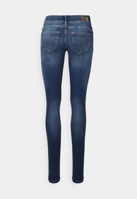 Jeans skinny azul-escuro feitos de denim, apresentando uma cintura de altura média, cinco bolsos e costura standard nos bolsos traseiros.
