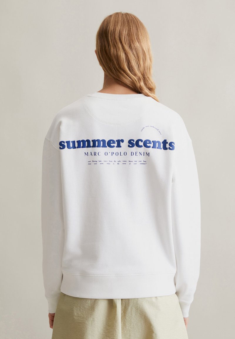 Witte sweatshirt met blauwe tekst waarin staat "zomerse geuren" en "MARC O'POLO DENIM" op de achterkant. Zacht materiaal met een ontspannen pasvorm.