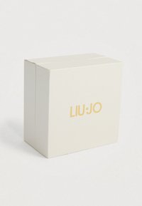 Λευκό κουτί δώρου με υφή και χρυσό λογότυπο "LIU·JO" μπροστά. Έχει τετράγωνο σχήμα με καθαρό, μινιμαλιστικό σχέδιο.