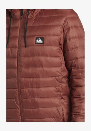 Bordeaux pufferjack met gestikte panelen, ritsluiting en een capuchon. Heeft een zwart logo-opdruk op de linkerborst. Gladde, glanzende textuur.