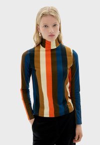 Rullekrave-top med lodrette striber i brun, blå, orange og creme. Figurformet design med lange ærmer og en blød tekstur.