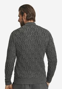 Szary sweter dzianinowy z teksturowanym wzorem w diamenty, prążkowanym kołnierzem, mankietami i dolnym brzegiem. Wzór ma średnią grubość i dopasowany krój.