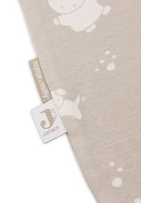 Tissu en coton beige présentant un motif doux d'un lapin et d'empreintes de pattes. Comprend deux étiquettes : l'une avec "Miffy" et l'autre avec "Jollein."