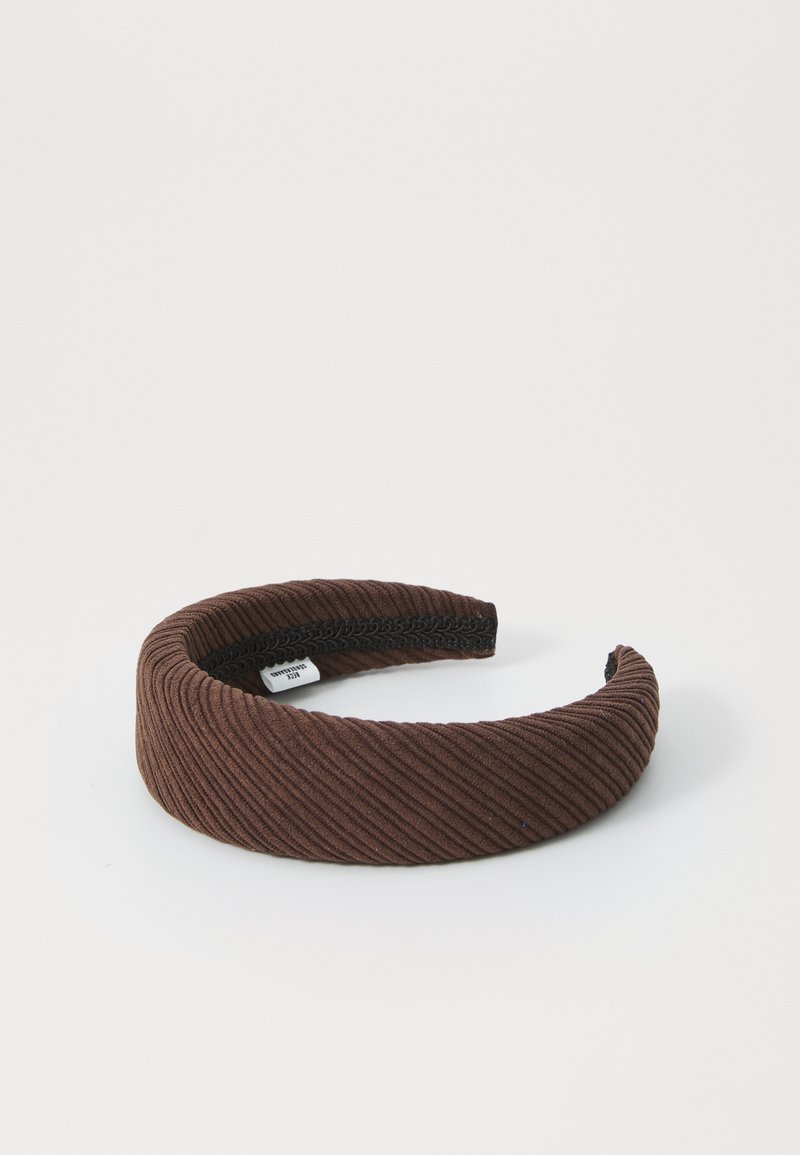 Hnědý kordurový čelenka s ribbovanou texturou, jednoduchý design a černá vnitřní guma pro uchopení a pohodlí.
