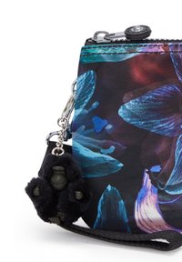 Portafoglio con motivo floreale in nero, realizzato in tessuto con cerniera. Presenta un ciondolo in peluche nero a forma di gorilla che tiene una piccola figura.