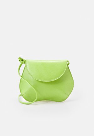 Petit sac bandoulière en cuir vert citron avec des bords inférieurs courbés et une fermeture à rabat sur un fond clair uni.