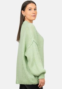 Maglione di maglia leggero e oversize in verde pastello, con una vestibilità ampia, spalle cadute e orlo e polsini a coste. Finitura texture.