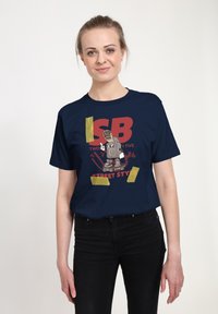 Námořnická modrá bavlněná tričko s grafickým designem a tučnou červenou typografií, doplněné ilustrací reproduktoru na skateboardu, zvýrazněné žlutou páskou.