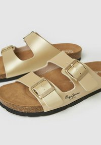 Sandalias beige de punta abierta con dos correas ajustables con hebilla y plantillas de corcho, con suelas negras y la marca "Pepe Jeans London".